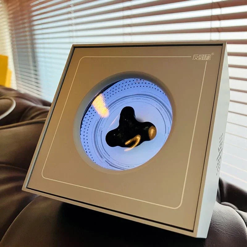 A sleek square display box with a circular window showcasing a black and gold venom sensor ferrofluid magnetic pickup device