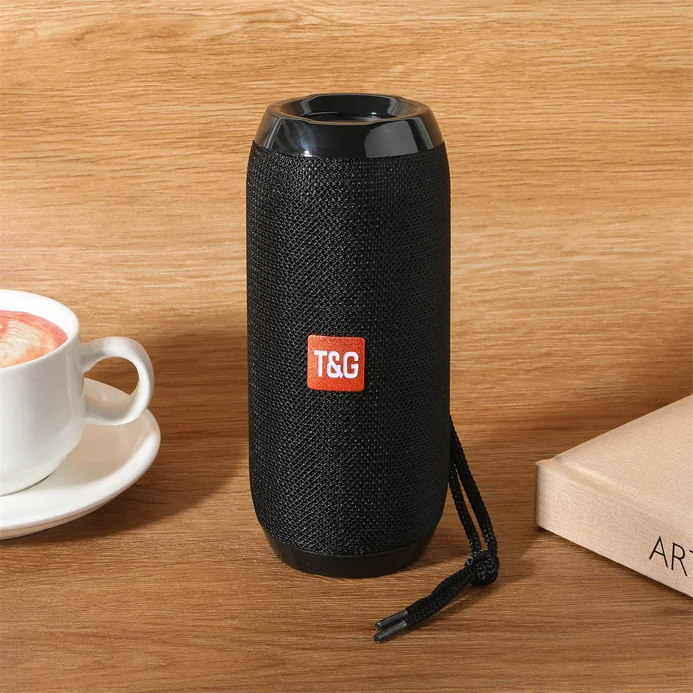 Black fabric-wrapped portable wireless bluetooth speaker with glossy top and orange t&g logo for som blootooth subwoofer use