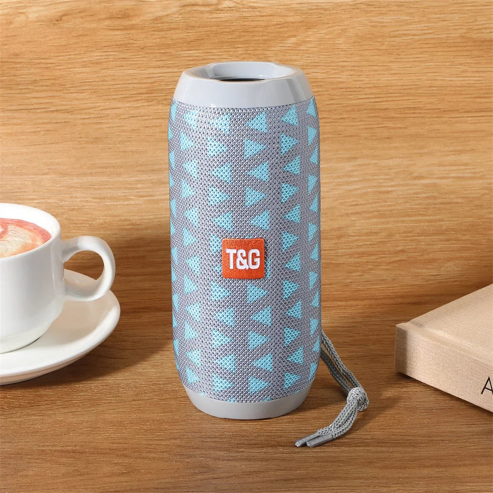 Portable wireless bluetooth cylindrical speaker with gray mesh and blue patterns featuring radio fm handfree functionality