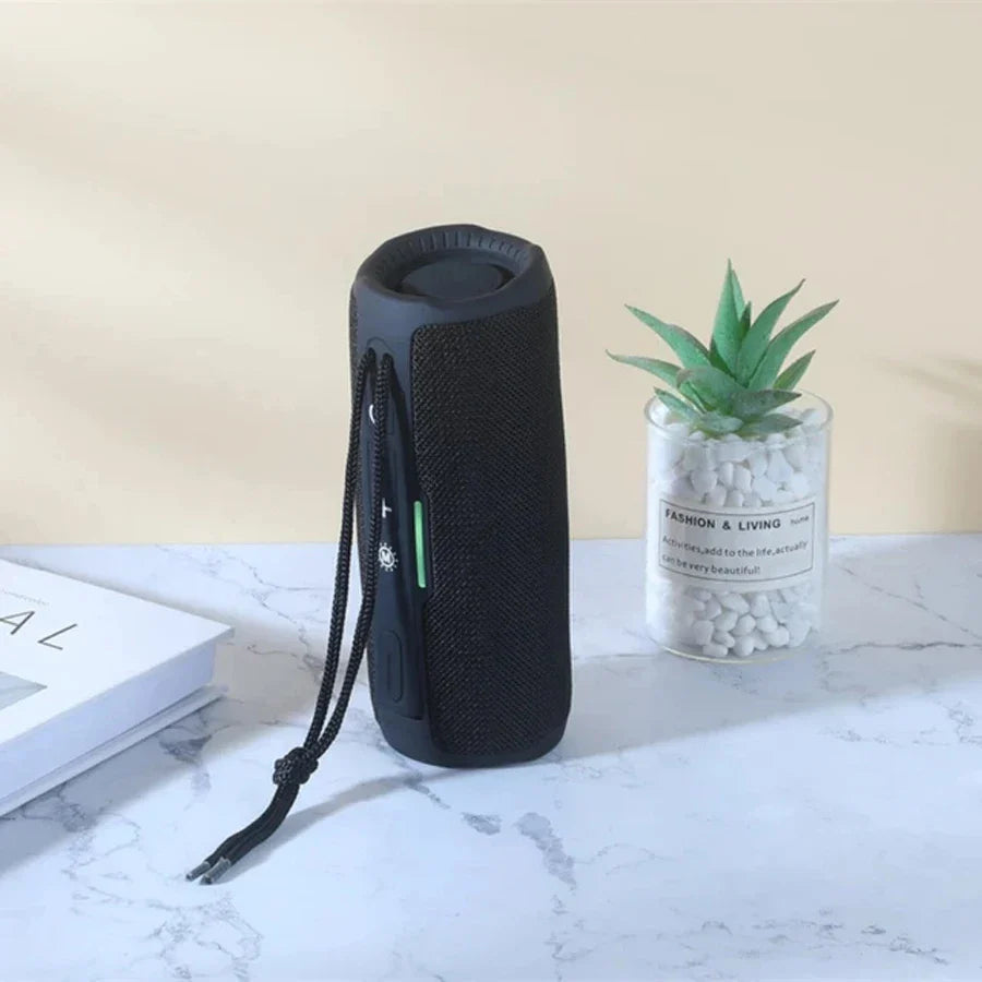 Black fabric-wrapped portable wireless bluetooth speaker with carrying strap and green power indicator for radio fm handfree use