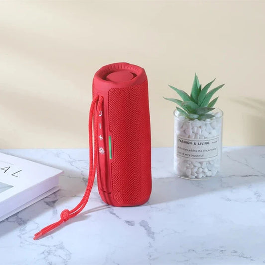 Red cylindrical portable wireless bluetooth speaker with textured fabric exterior and matching carrying strap for radio fm handfree use