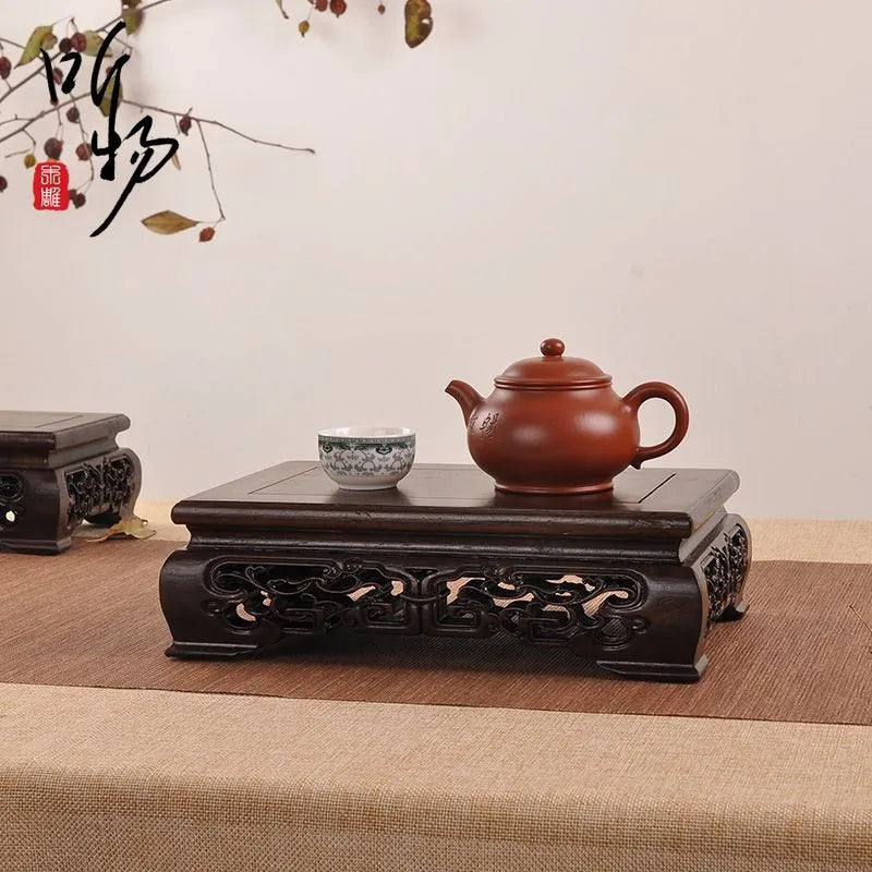 A traditional reddish-brown clay teapot on a premium wooden pedestal for coffee tea sets figurines vases flower display