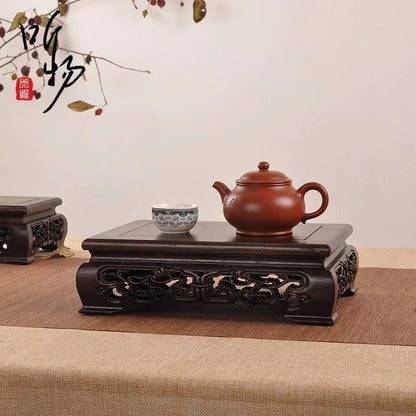A traditional reddish-brown clay teapot on a premium wooden pedestal for coffee tea sets figurines vases flower display