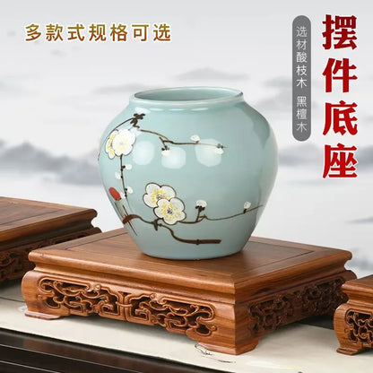 A light blue ceramic vase with white plum blossoms on a premium wooden pedestal for figurines vases flower display