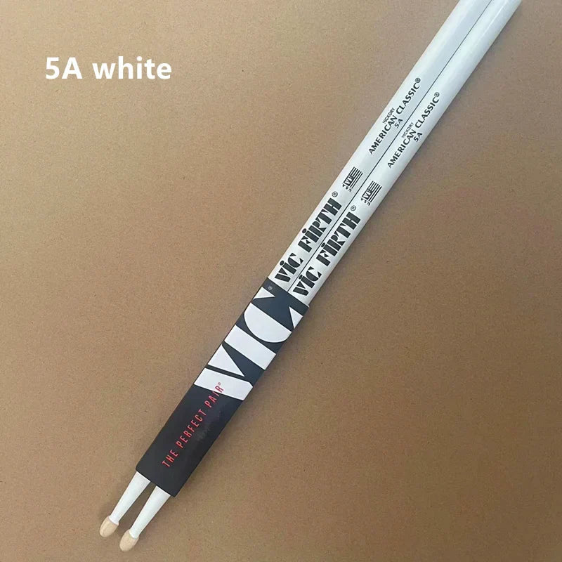 White professional vic firth drumsticks 5a with black and red branding on tan surface for jazz rock durable use