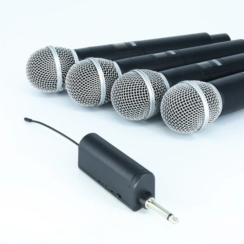 Set of four black professional wireless microphones with silver mesh grilles and matching receiver for channels karaoke handheld use