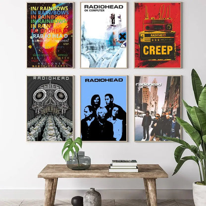 Six framed radiohead album posters with vibrant lighting effects above rustic wooden table for living room decor