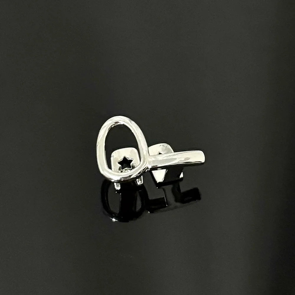 Silver key-shaped earring with star cutout and polished finish, complementing gold teeth and mouth grillz care products