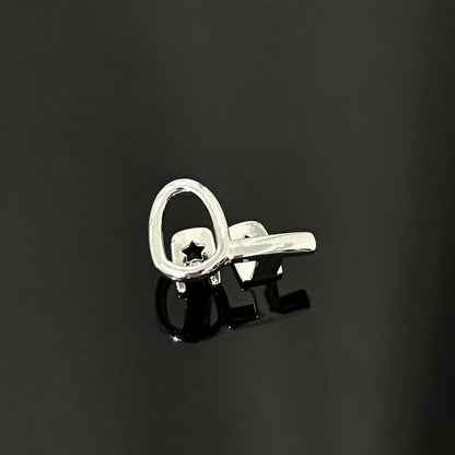 Silver key-shaped earring with star cutout and polished finish, complementing gold teeth and mouth grillz care products