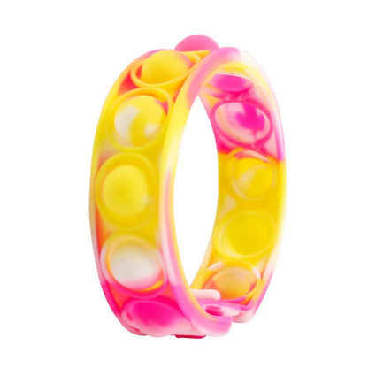 A vibrant yellow and pink silicone push bubble antistress ring with marbled design for stress relief sensory play
