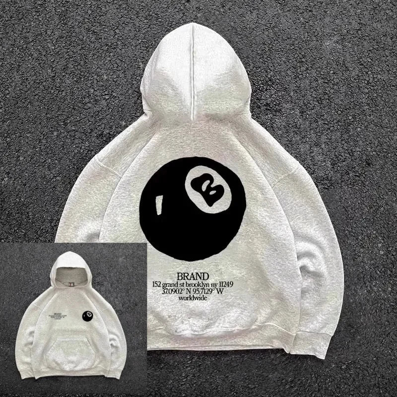 Back of a white oversized pullover with a retro 8-ball pattern and text in hooded men’s streetwear style