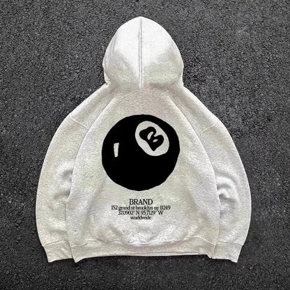 Cream-colored hooded men’s streetwear pullover with large retro 8-ball pattern on the back for casual wear