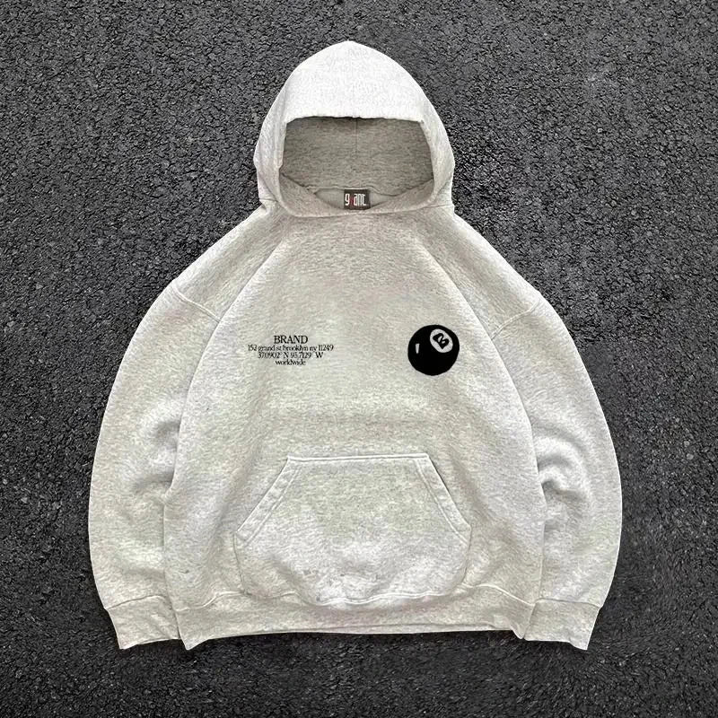 A light gray oversized pullover hoodie with a black retro 8-ball pattern logo for hooded men’s streetwear casual use