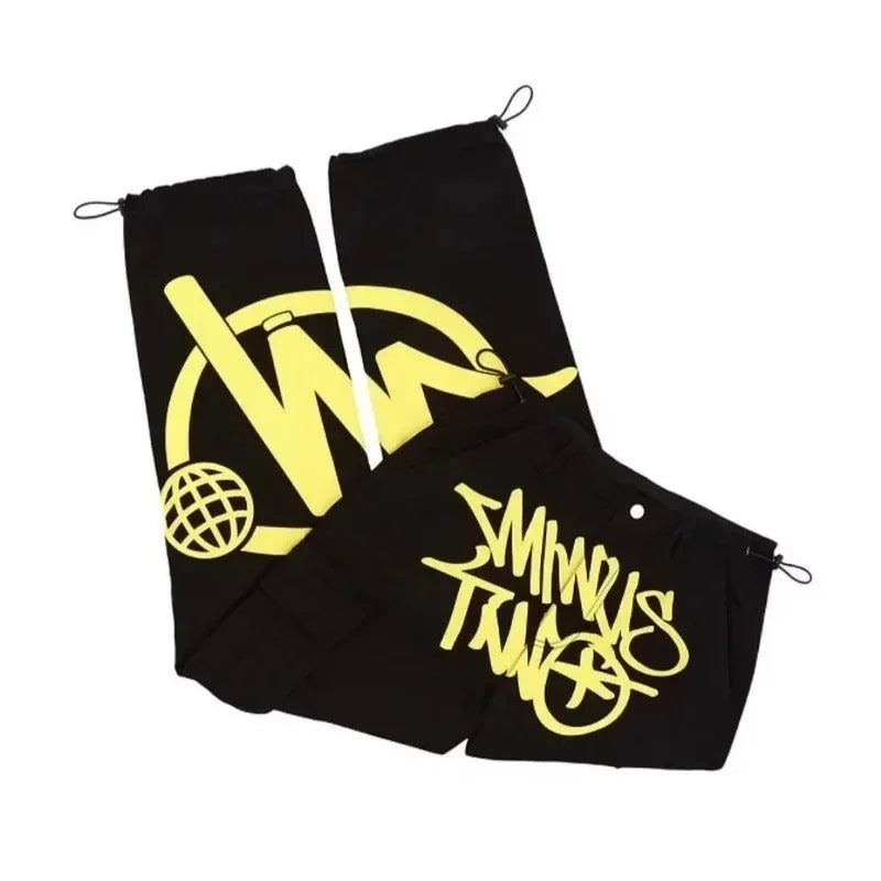 Black drawstring pouches with bold yellow graffiti logos and globe graphic complement casual loose workwear for men dance scene