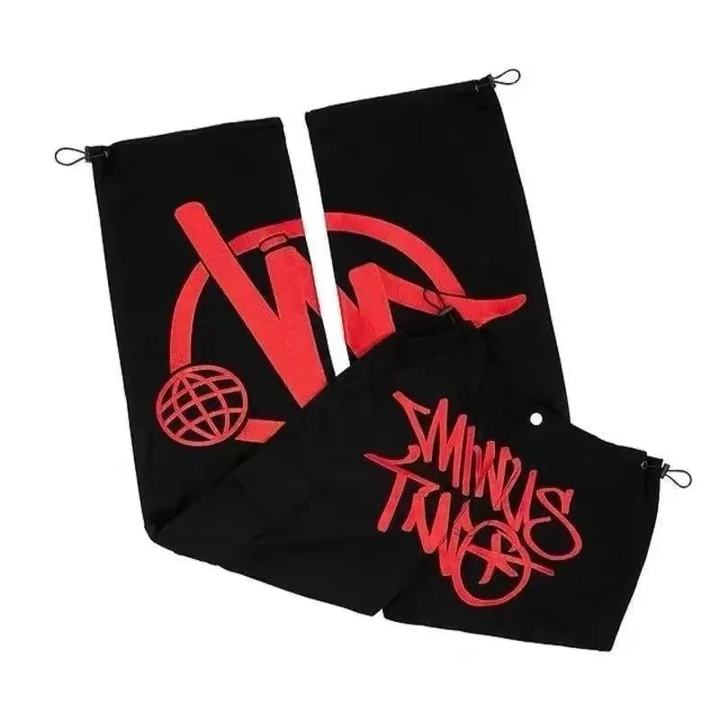 Black drawstring pouches with bold red graphic designs complement men dance scene casual loose workwear trousers