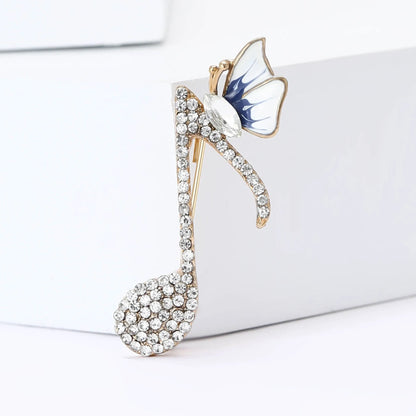 A gold-tone rhinestone butterfly pin with clear crystals and blue-white enamel for event party backpack decoration