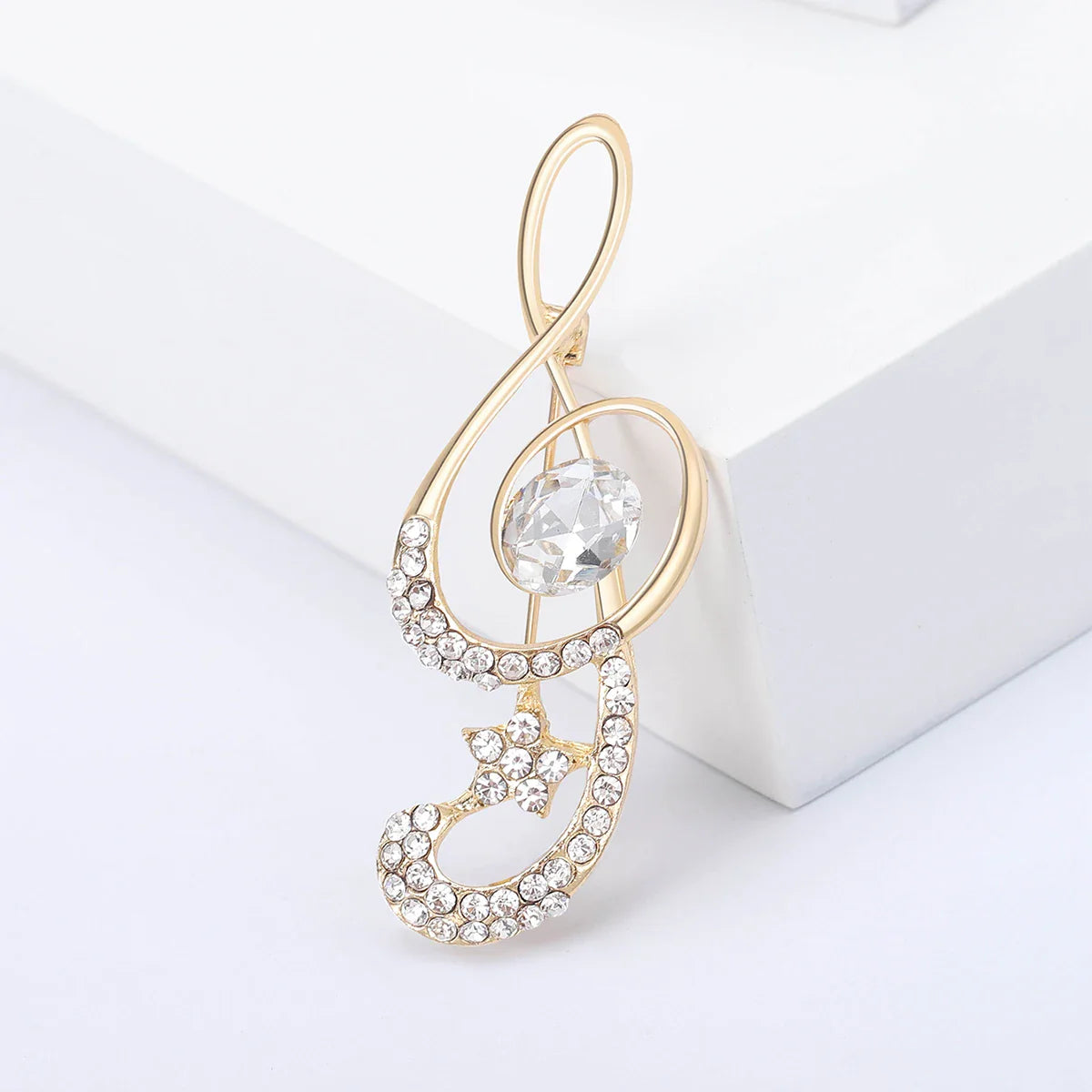 Gold-tone musical treble clef brooch with rhinestones and central oval gemstone for event party backpack accessory