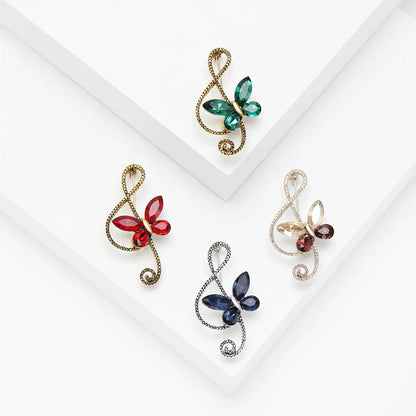 Four rhinestone butterfly pins with shiny glass musical note designs in green red blue and amber for event party backpack decoration