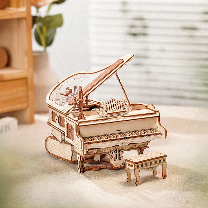 A delicately crafted light wood mechanical music box magic piano model kit with intricate laser-cut details and matching stool