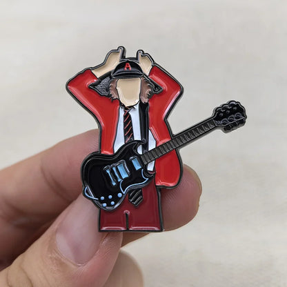 Red and black enamel pin featuring a stylized guitarist in a red jacket holding a black electric guitar for music fans