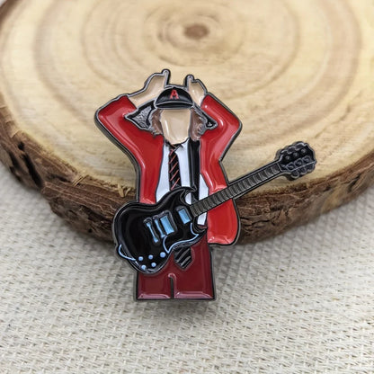 Red enamel pin of a stylized guitarist in a red jacket and black hat holding a black electric guitar for fans gift