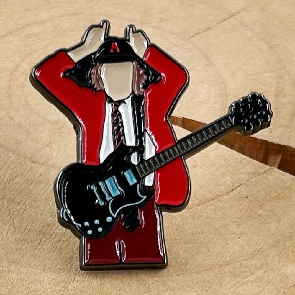 Red enamel pin featuring badge guitarist angus young in red jacket holding black electric guitar with blue accents for music fans