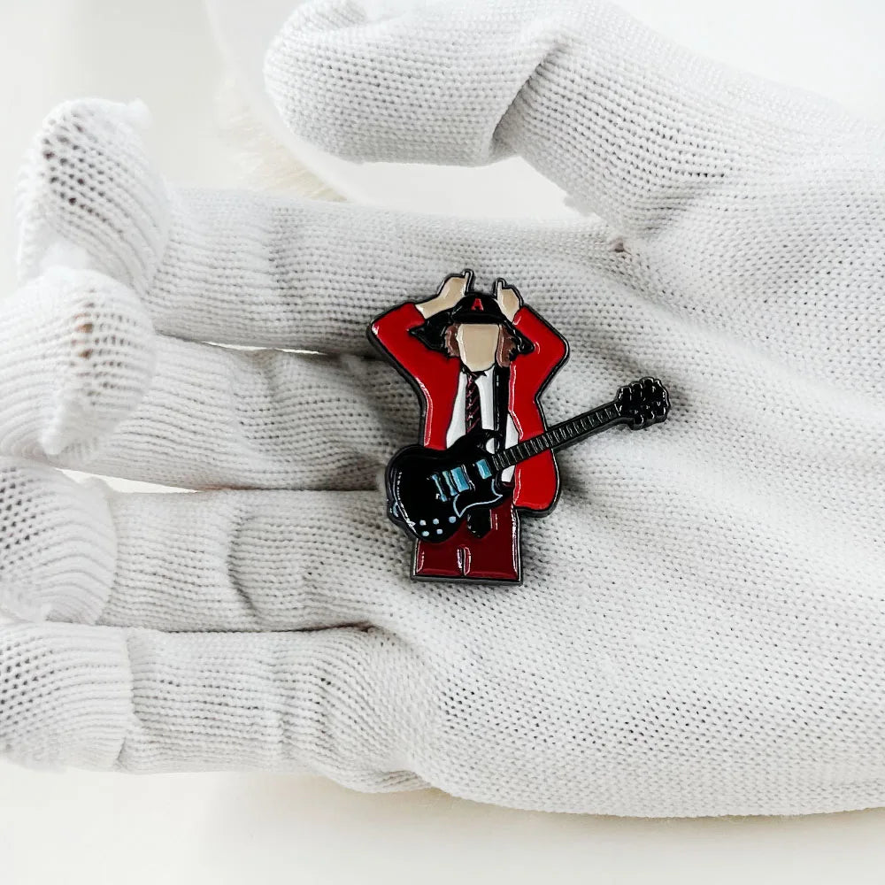 Red enamel pin music badge featuring stylized badge guitarist angus young in red suit holding black electric guitar