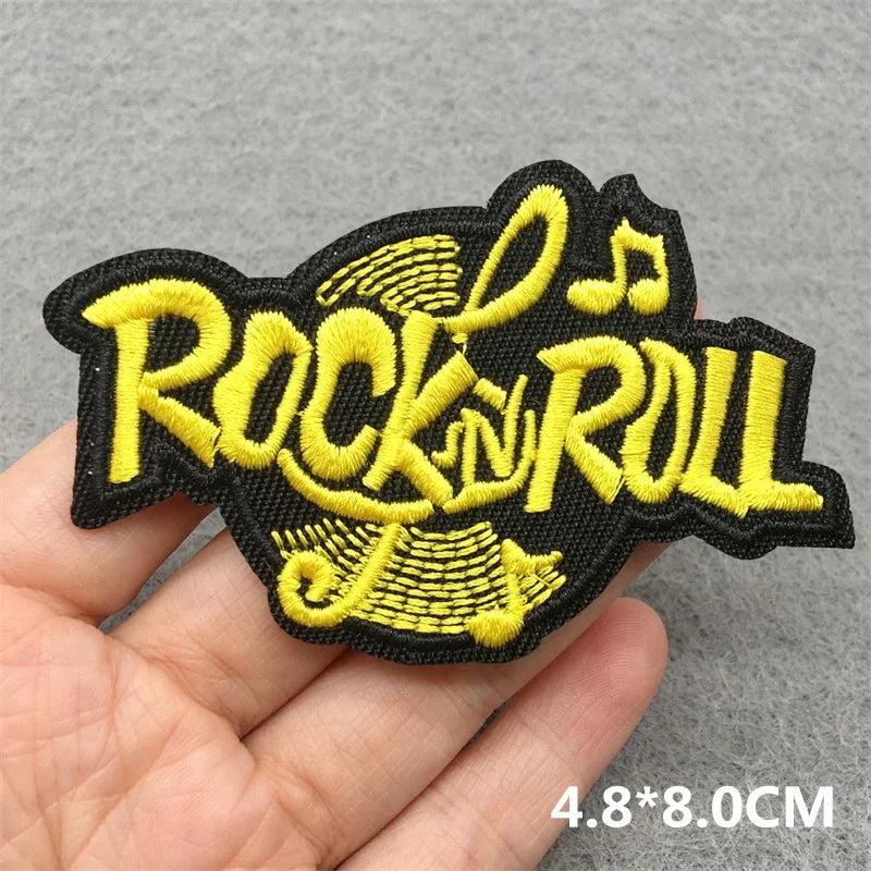 A vibrant yellow rock n roll music embroidered patch with black outline on dark fabric for jacket jeans headset clothes stickers diy