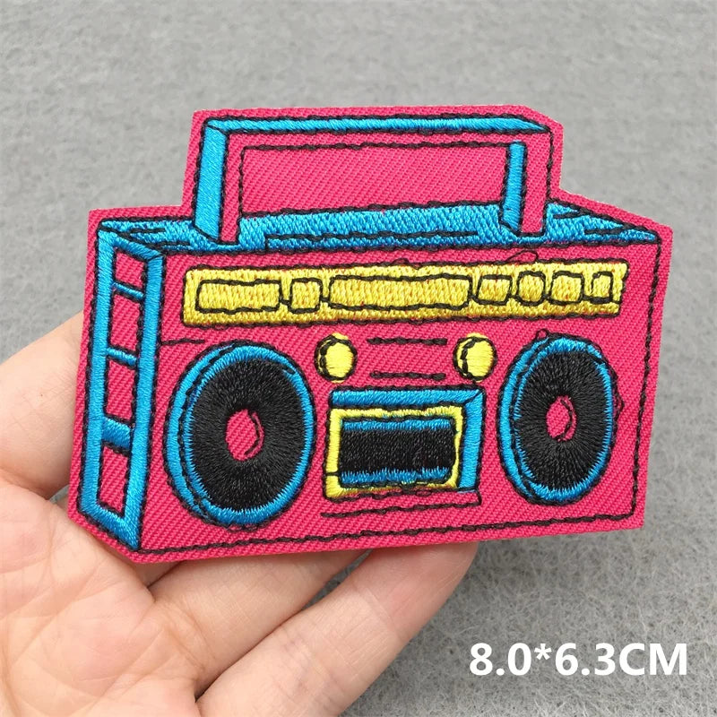 Vibrant pink and blue music embroidered patch of a classic boombox with yellow accents for clothes stickers diy on jacket jeans headset