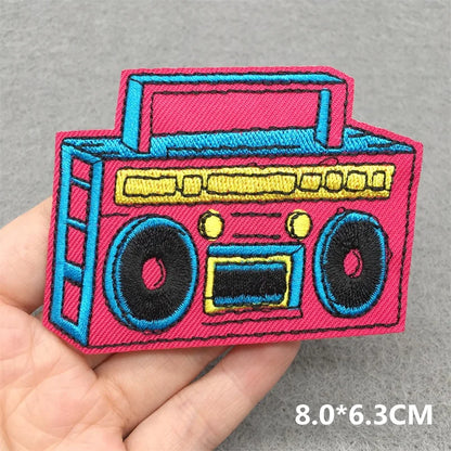 Vibrant pink and blue music embroidered patch of a classic boombox with yellow accents for clothes stickers diy on jacket jeans headset