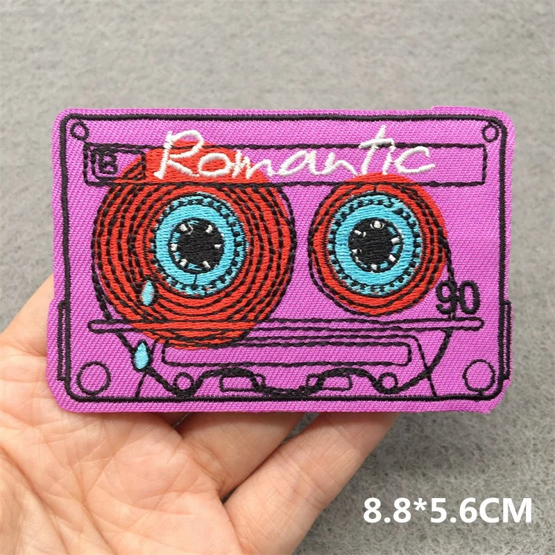 A vibrant pink music embroidered patch shaped like a cassette tape for clothes stickers diy on jacket jeans headset