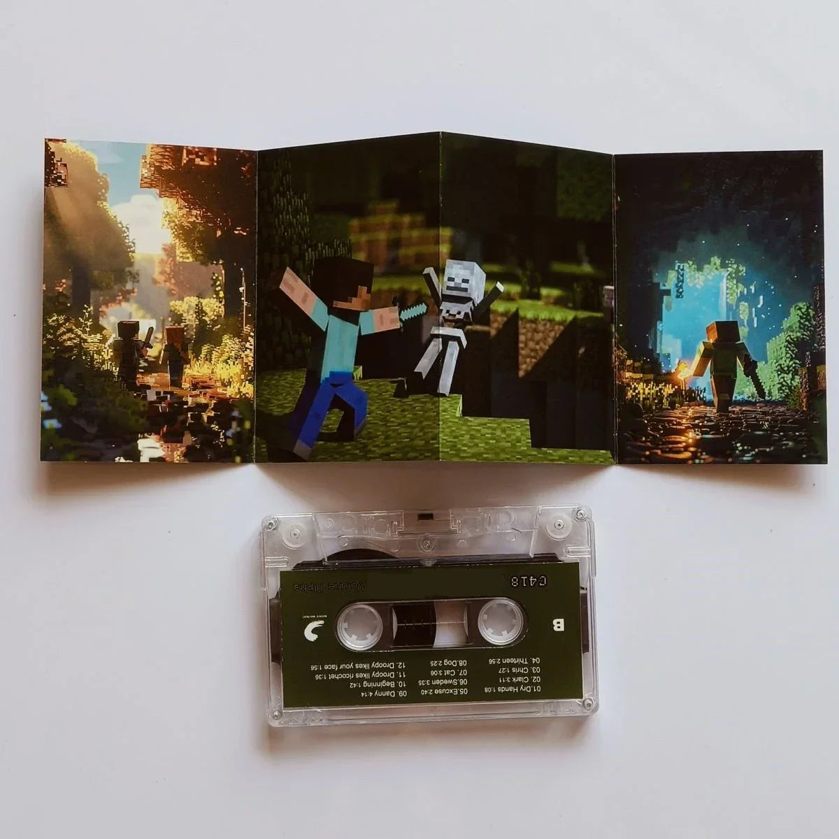 Clear plastic cassette tape with dark green minecraft label and tri-fold pixel art album cover for daniel rosenfeld music