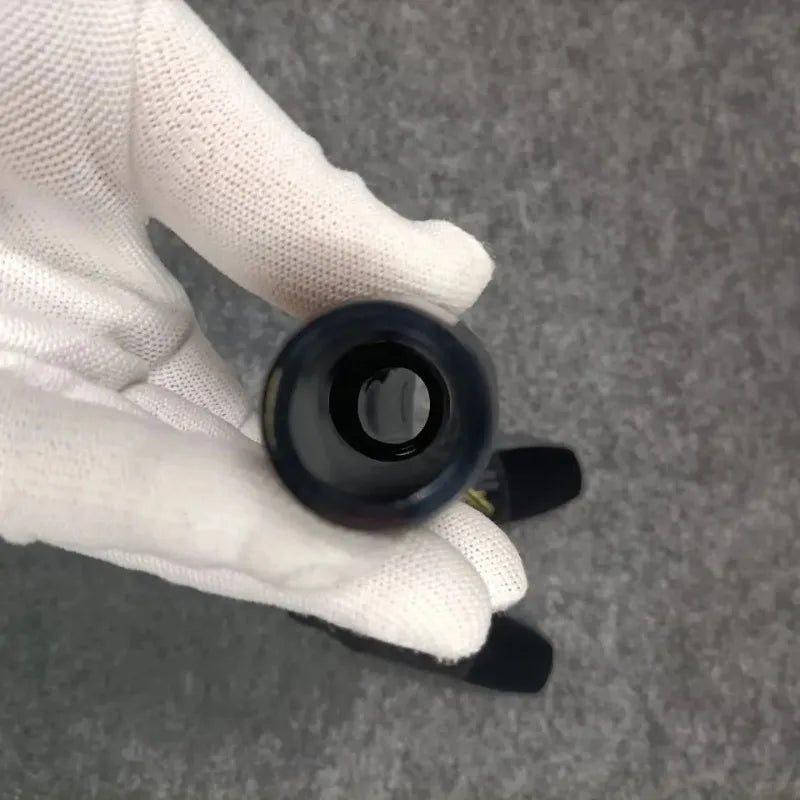 A sleek glossy black cylindrical saxophone head curdlin with a smooth polished surface and central hole for al5 alto saxophone