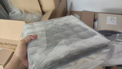 A hand holding gray quilted self-adhesive soundproof foam panels for eggcrate acoustic wall soundproofing