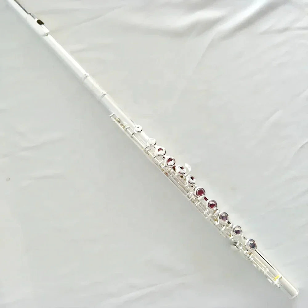 A sleek silver plated high quality flute with 16 holes and red gemstone accents, ideal for reed glove cleaning