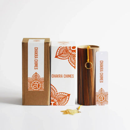 A polished wooden seventh chord wind chime with a golden ring handle and orange mandala packaging for meditation yoga japanese use