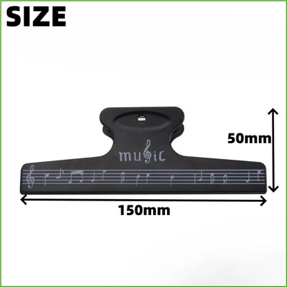 Black plastic sheet music clip with musical notes and music engraving used as score fixed clips for instruments