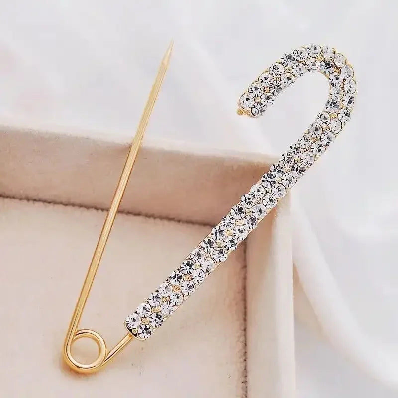 Gold-toned safety pin brooch adorned with sparkling clear rhinestones for exquisite clothing decoration