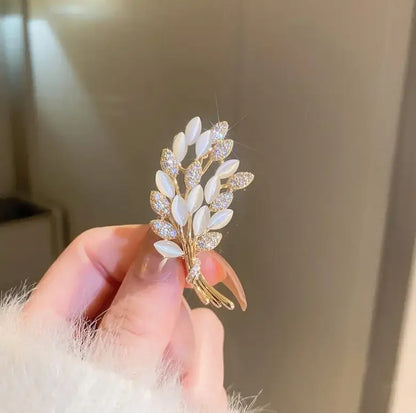 Gold-toned leaf brooch with white mother-of-pearl leaves and sparkling rhinestones for elegant music accessory use