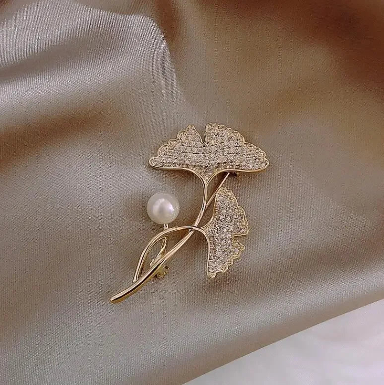 Gold-toned ginkgo leaf brooch with crystal detailing and central pearl for women music accessory and clothing decoration