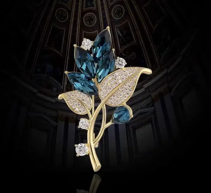 Gold-toned floral brooch with deep blue marquise crystals and clear diamonds for music accessory and clothing decoration