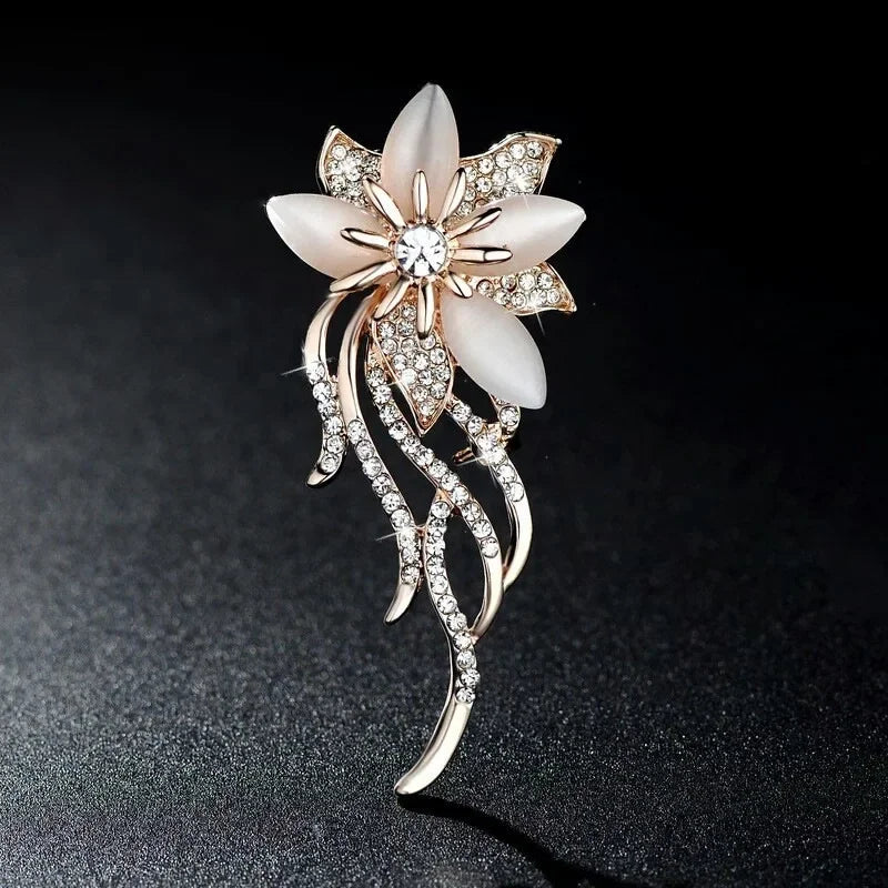 A delicate white mother-of-pearl flower brooch with rose gold metal and sparkling rhinestones for clothing decoration