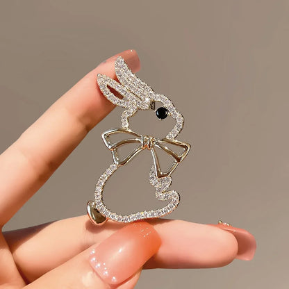 Delicate gold-toned rabbit brooch with sparkling crystals and black gemstone eye for elegant clothing decoration