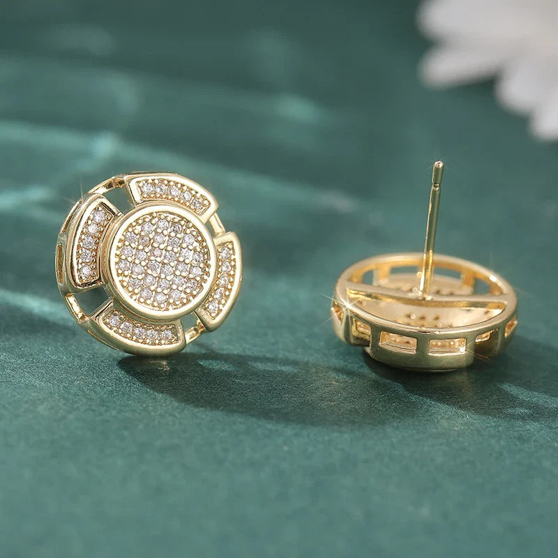 Gold-toned stud earrings with circular flower-like design and pave-set clear crystals for men and women