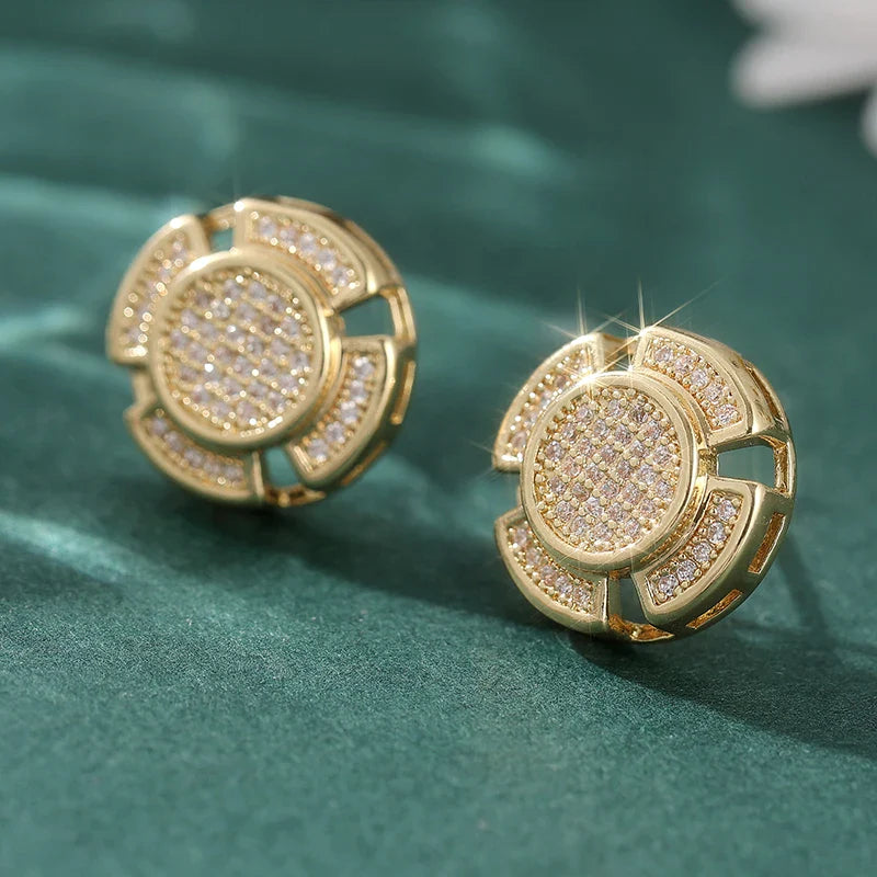 Gold-toned stud earrings with circular multi-layered design and intricate pave-set clear crystals for men women