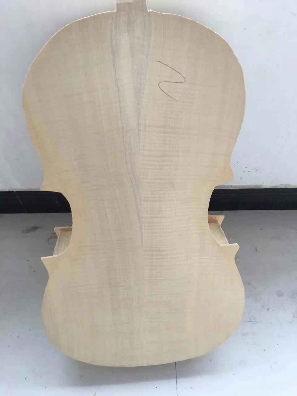 Unfinished light-colored sinomusik handmade custom white cello body with natural wood grain and f-shaped sound holes professional grade italian