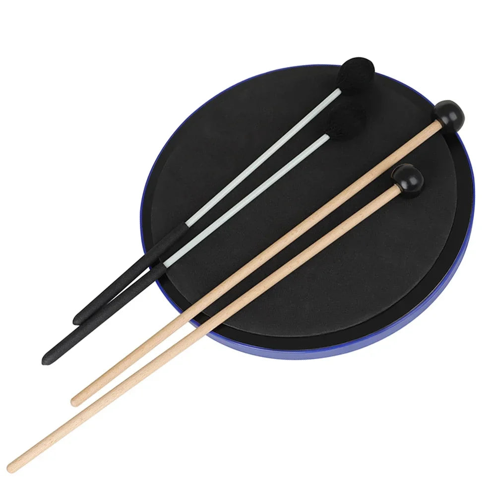 Black circular drum pad with blue rim and two wooden slade pair marimba drumsticks resting on top