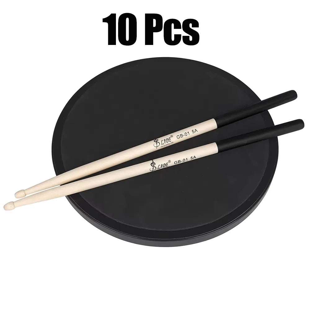 A pair of black and cream-colored slade 5a maple drumsticks professional resting on a black circular practice pad percussion accessories