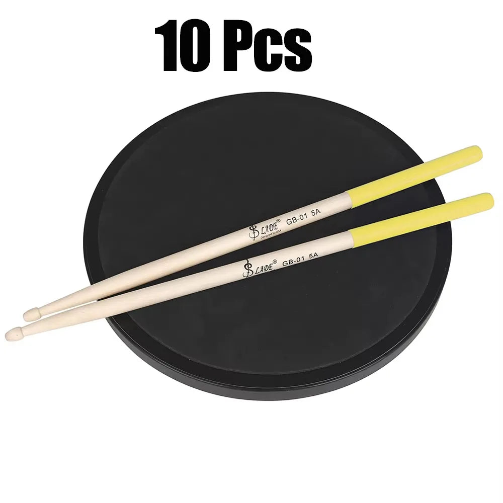 A pair of light-colored maple drumsticks professional with yellow tips resting on a black percussion accessories pad