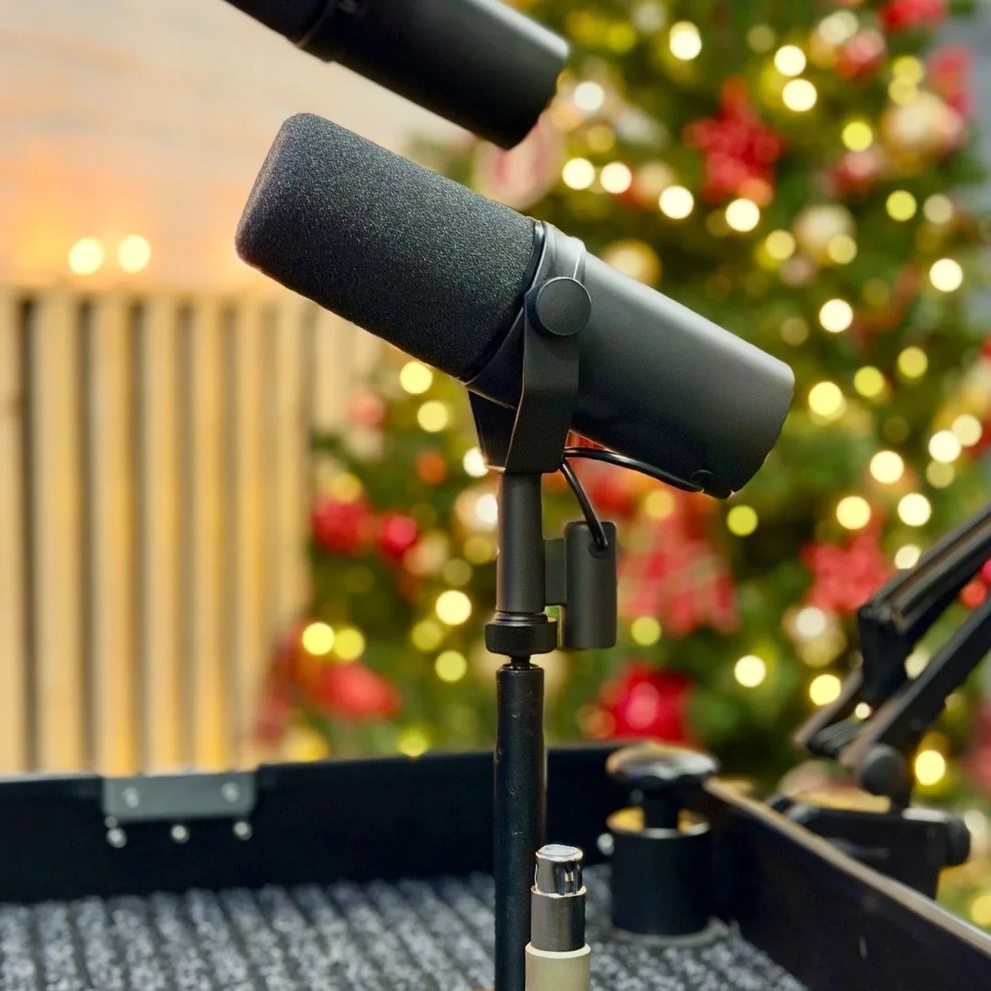 Black sm7b dynamic recording microphone with foam windscreen mounted on stand for live vocals performance